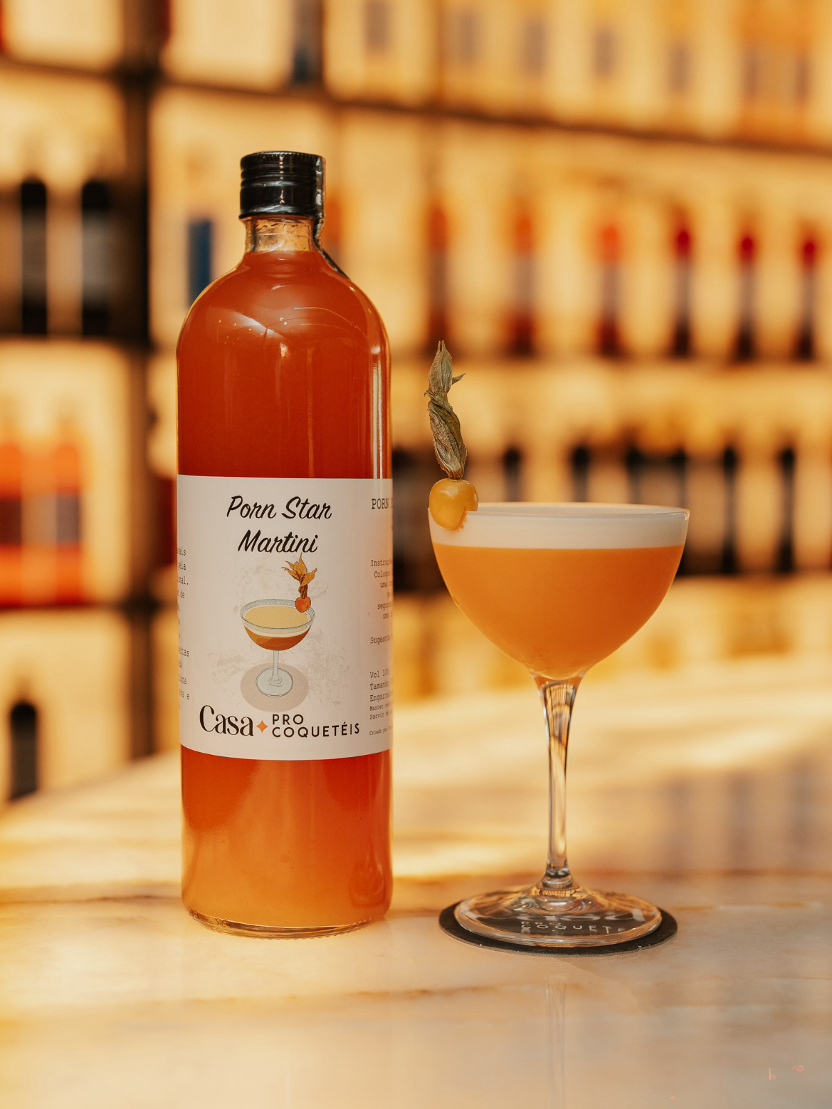Garrafa de Porn Star Martini da Casa Pro Coquetéis com a taça servida ao lado